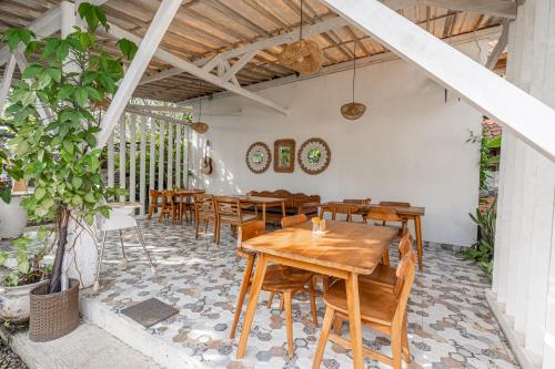 a dining room with wooden tables and chairs at Eiwa House in Ubud
