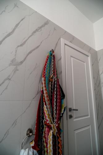 a bunch of ties hanging on a wall next to a door at La Corte di Partenope Luxury Suite in Naples