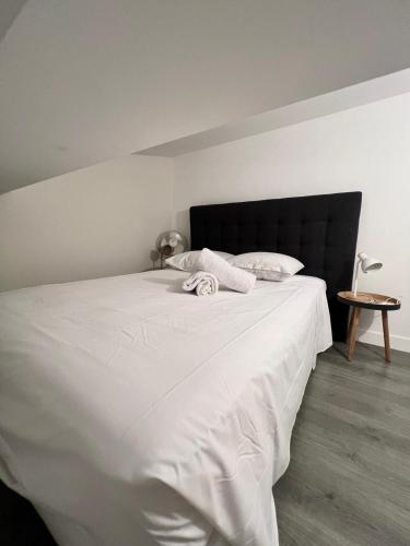 - un lit blanc avec une tête de lit noire dans une chambre dans l'établissement Spacieux T1 lumineux au cœur de Toulon, à Toulon