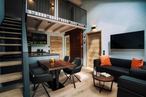 a living room with a couch and a table at Allgäuer Bergwald Chalets in Oberstaufen