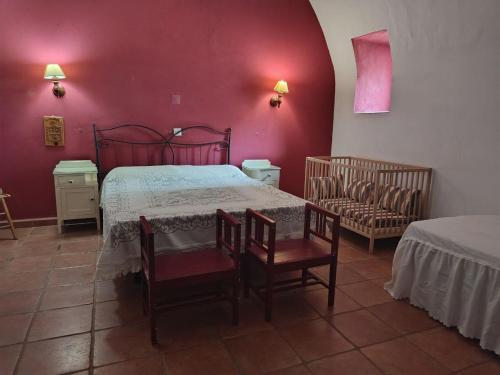 a bedroom with a bed and a table and chairs at Casa rural Finca Galapero in Alcántara