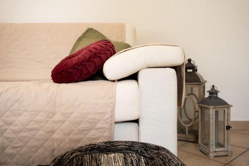 a white couch with two red pillows on it at Casa Peonia in Germignaga