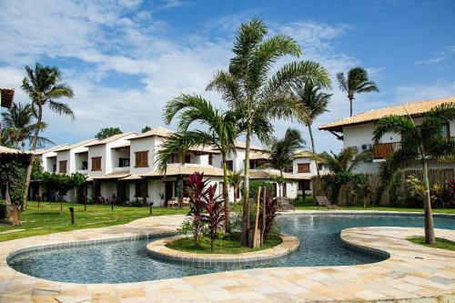 ein Resort mit Swimmingpool und Palmen in der Unterkunft Casa Cajú in Cruz