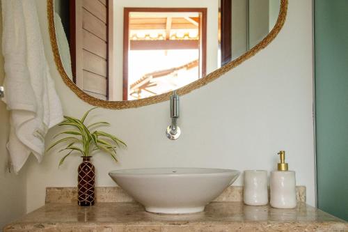 ein Badezimmer mit einem Waschbecken und einem Spiegel in der Unterkunft Casa Cajú in Cruz
