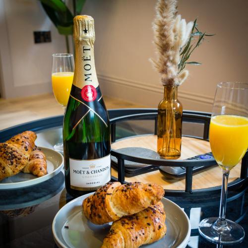 a bottle of wine and plates of food on a table at Stylish Manchester City Escape - Walk to Chinatown in Manchester