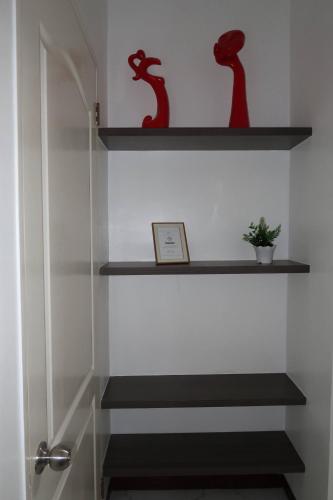 a staircase with shelves with red vases on them at Spacious Fully Furnished 2BR Condo in Mactan in Sudtungan