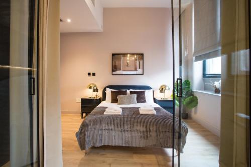 a bedroom with a bed and a mirror at Stylish Manchester City Escape - Walk to Chinatown in Manchester