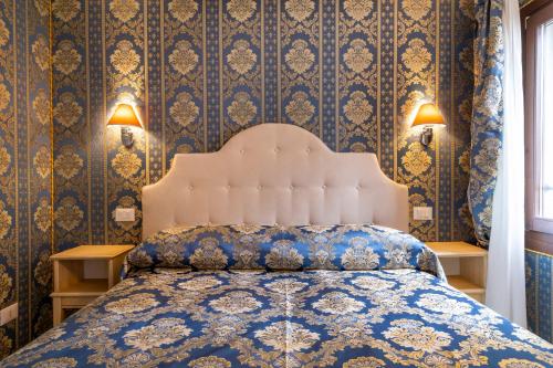 a bedroom with a bed with a blue and gold wallpaper at Cà Beatrice in Venice