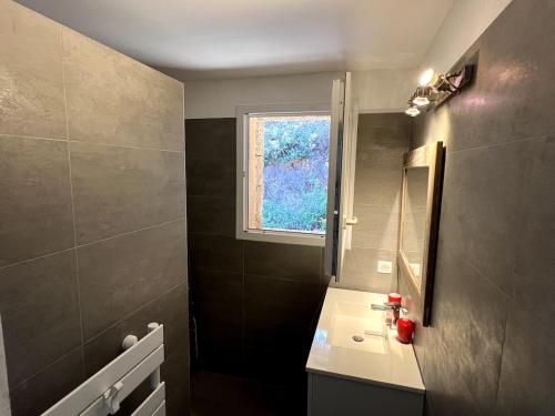 une salle de bain avec un lavabo et une fenêtre dans l'établissement Villa with pool, sea view, Ste Lucie de Porto-Vecchio, à Conca