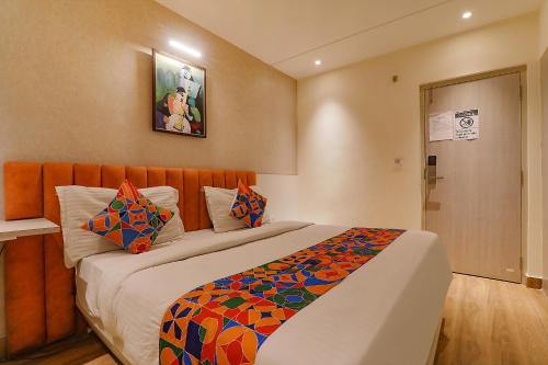 Un dormitorio con una cama grande con una manta colorida. en FabHotel Geetraj Palace, en Lucknow