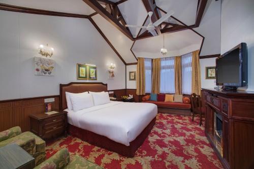 a hotel room with a bed and a television at Mayfair Darjeeling in Darjeeling