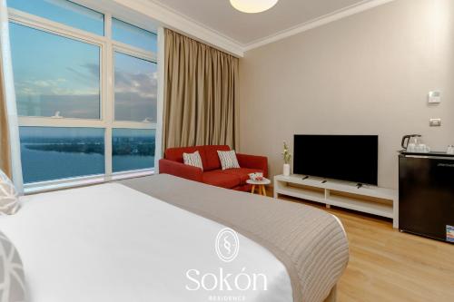 a hotel room with a large bed and a large window at Sokon Residence Partial Nile view at Maadi in Cairo