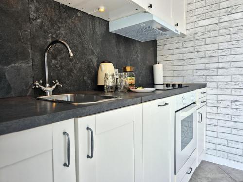 a kitchen with white cabinets and a sink at Apart 36 in Lębork