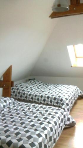 - une chambre avec une couette en noir et blanc sur un lit dans l'établissement dans corps de ferme en Picardie, à Valines