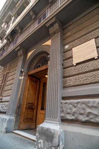 a building with a wooden door with a sign on it at La Corte di Partenope Luxury Suite in Naples