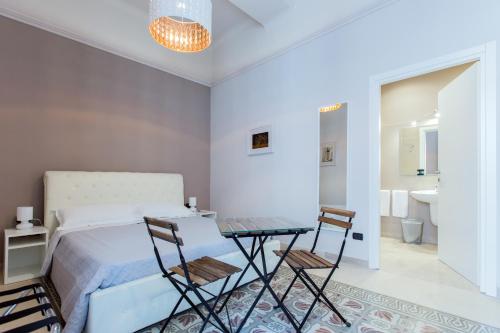1 dormitorio con 1 cama, mesa y sillas en Matera In Vacanza, en Matera