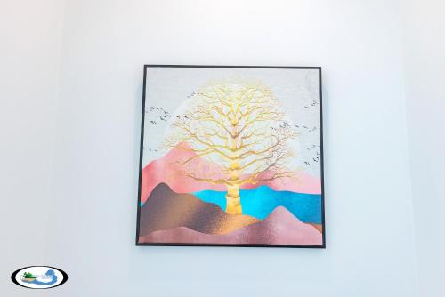 a framed painting of a tree on a mountain at Oscar Seaview Apartment in Phu Quoc
