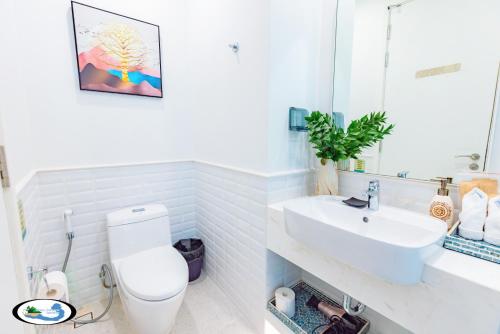 a bathroom with a white toilet and a sink at Oscar Seaview Apartment in Phu Quoc