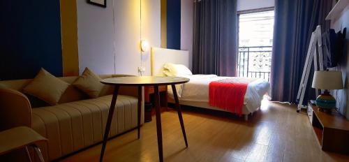 a hotel room with a bed and a couch and a table at YuMi Gaopai in Guangzhou