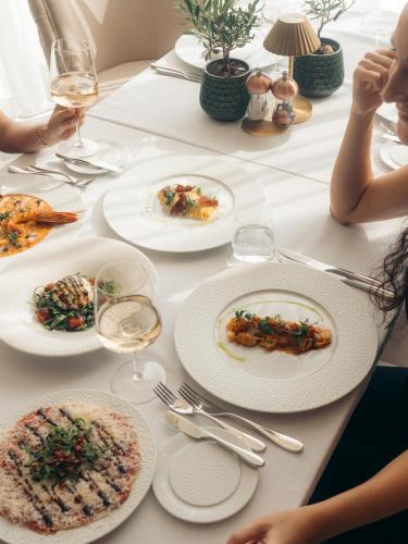 a white table with plates of food on it at Rixos The Palm Hotel & Suites - Ultra All Inclusive in Dubai