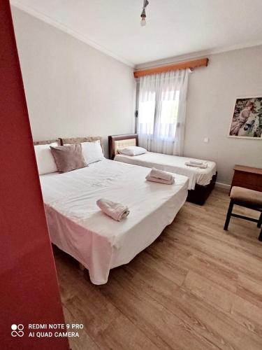 a bedroom with two beds and a window at Himara City-Center Apartment in Himare