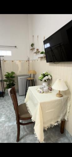 a dining room table with a white table cloth and a lamp at Hotel Ngọc My in Phan Thiet