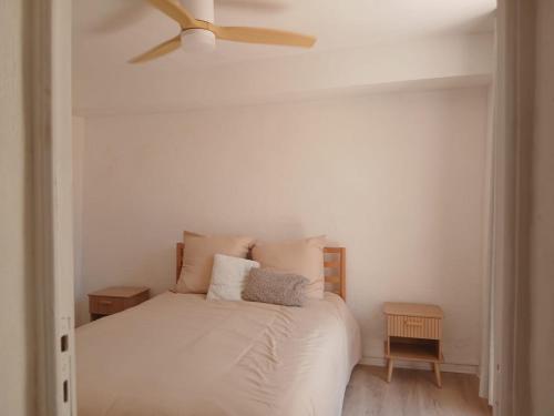 une chambre avec un lit blanc avec un ventilateur de plafond dans l'établissement Très bel appartement refait à neuf dans la vieille ville de Hyères, 2 chambres, grande terrasse plein sud, à Hyères