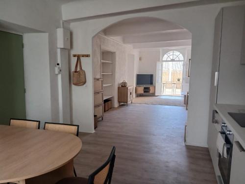 une salle à manger avec une table et une cuisine dans l'établissement Très bel appartement refait à neuf dans la vieille ville de Hyères, 2 chambres, grande terrasse plein sud, à Hyères