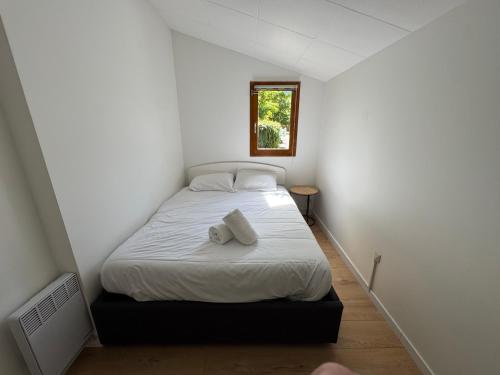 - une petite chambre avec un lit blanc et une fenêtre dans l'établissement Chalet Familial au bord du lac, à Doussard