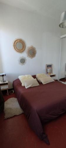 une chambre avec un lit et deux miroirs au mur dans l'établissement Location saisonnière Maison Pointe Rouge Marseille 8, à Marseille