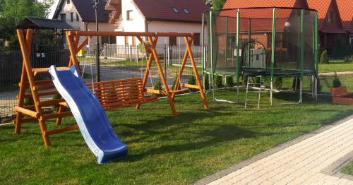 a playground with a slide and a swing at 365PAM - Urocze Domki Letniskowe blisko morza in Bobolin