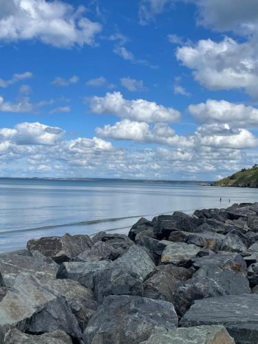 a group of rocks on the shore of a body of water at La perle de la Baie in Plérin