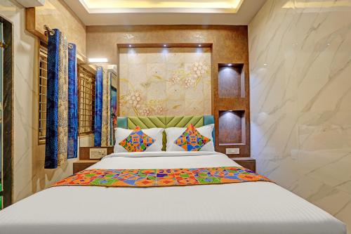 a bedroom with a large white bed with colorful pillows at FabHotel Saravana Shelters Residency - Nr Tambaram Railway Station in Chennai