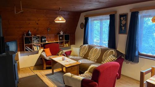 a living room with a couch and chairs and a table at Chata Buková 