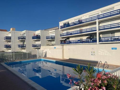 un immeuble avec une piscine devant un immeuble dans l'établissement Appartement T2+Cabine à Port Leucate - Piscine, Plage à Proximité, Parking Privé - FR-1-81-423, à Port-Leucate