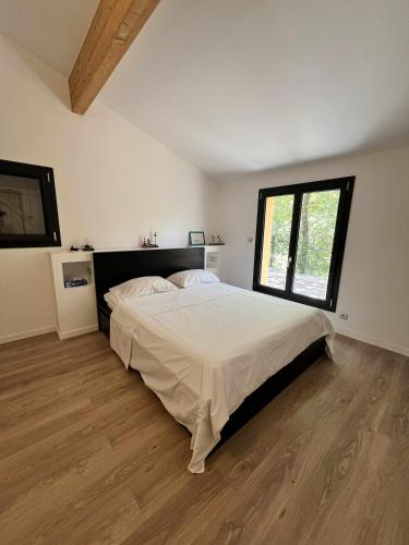 une chambre avec un lit et une grande fenêtre dans l'établissement cozy Home stay, à Mimet