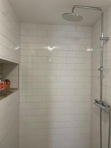 a white tiled shower with a glass door at Casa del Rellotge in Benifallet