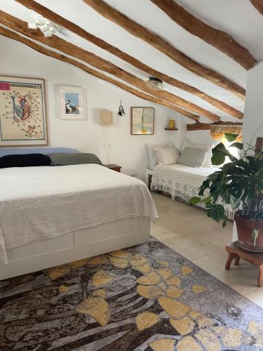 a bedroom with two beds and a rug at Casa del Rellotge in Benifallet