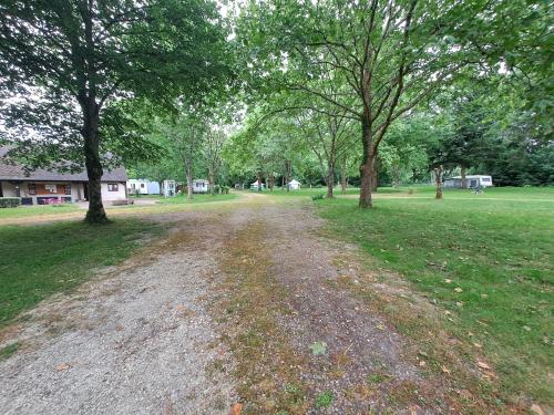 un chemin de terre dans un parc arboré dans l'établissement Camping Paradis Nature, à Ivoy-le-Pré