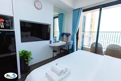 a hotel room with a large bed and a balcony at Oscar Seaview Apartment in Phu Quoc