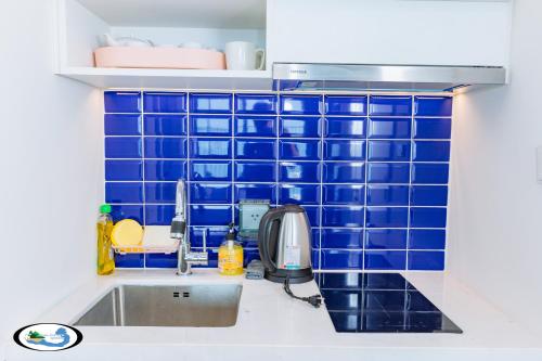 a blue tiled wall in a kitchen with a sink at Oscar Seaview Apartment in Phu Quoc