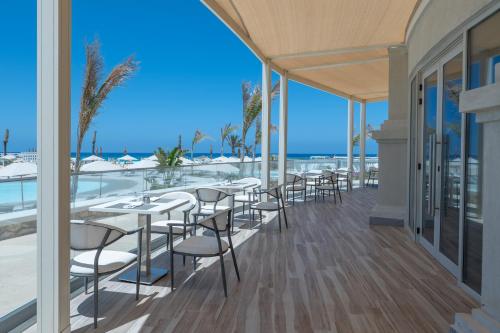 a restaurant with tables and chairs on a balcony at Cleopatra Sidi Heneish in Marsa Matruh
