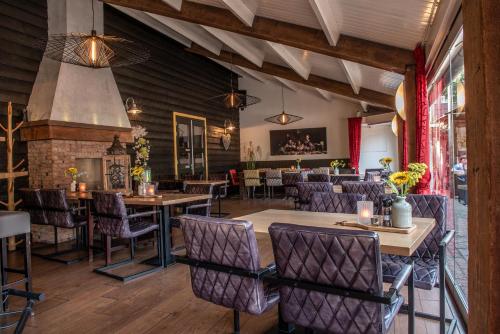 a restaurant with tables and chairs and a fireplace at Herberg de Brabantse Kluis in Aarle-Rixtel