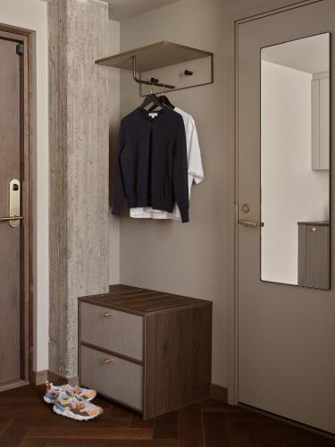 a room with a dresser and a shirt hanging on a wall at Bob W Helsinki Kamppi in Helsinki