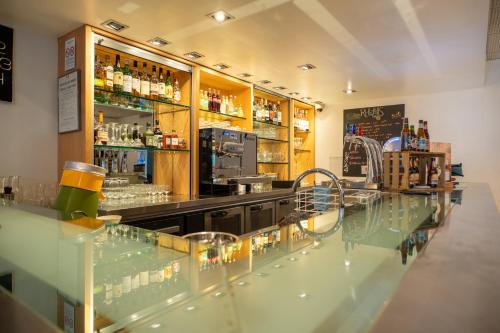 a bar with a glass counter in a room at Novotel Poissy Orgeval in Orgeval
