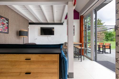 a living room with a sliding glass door and a television at Apartamenty za Leśniczówką in Stegna