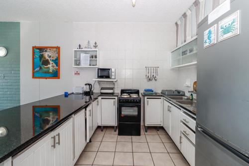a kitchen with white cabinets and a stove top oven at Seagull 302 in Margate