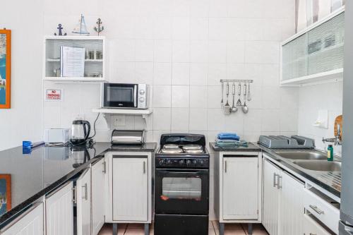 a kitchen with a stove and a microwave at Seagull 302 in Margate