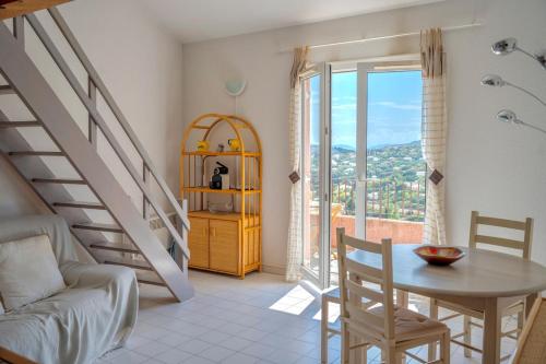 un salon avec une table et un escalier dans l'établissement Les Cigalines Appartement avec Piscine, à Cavalaire-sur-Mer