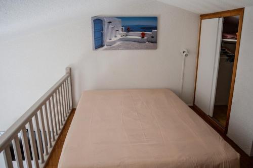 - un lit dans une chambre avec une photo sur le mur dans l'établissement Les Cigalines Appartement avec Piscine, à Cavalaire-sur-Mer